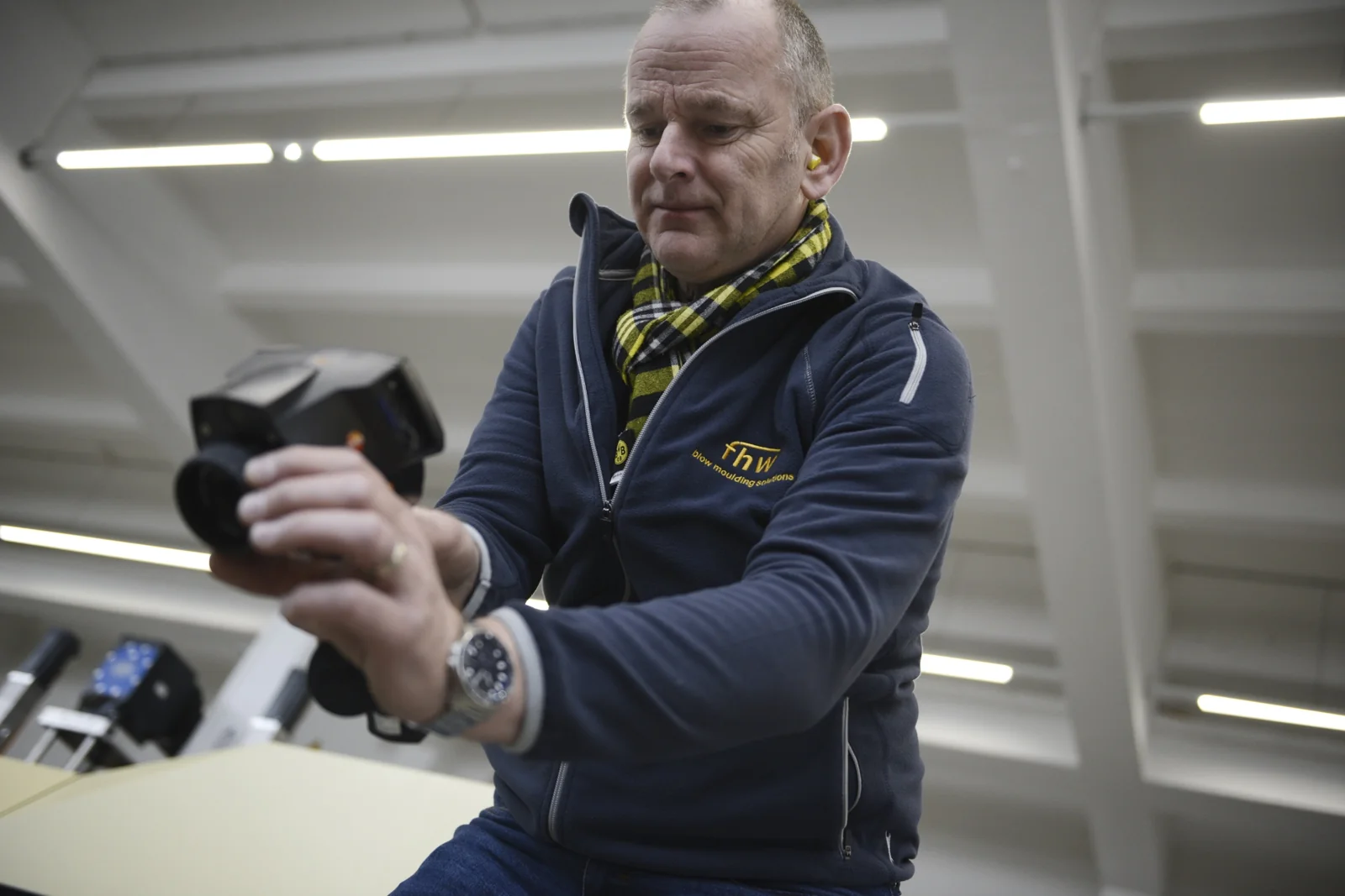 Andreas Lichtenauer prüft ein technisches Bauteil in der Produktion